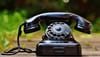 selective focus photography of black rotary phone